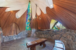 Experience a warm and inviting atmosphere in this rustic space with a vaulted ceiling, colorful stained glass window, and comfortable seating area.