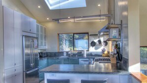 A modern kitchen with a large island, stainless steel appliances, and a view of the outdoors. - 3BR for 6 | Near Beach | Hot Tub | Ocean Views (Sea Ranch)