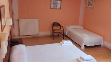 Habitación triple básica, 3 camas individuales, balcón | Espacio para trabajar con un portátil y tabla de planchar con plancha