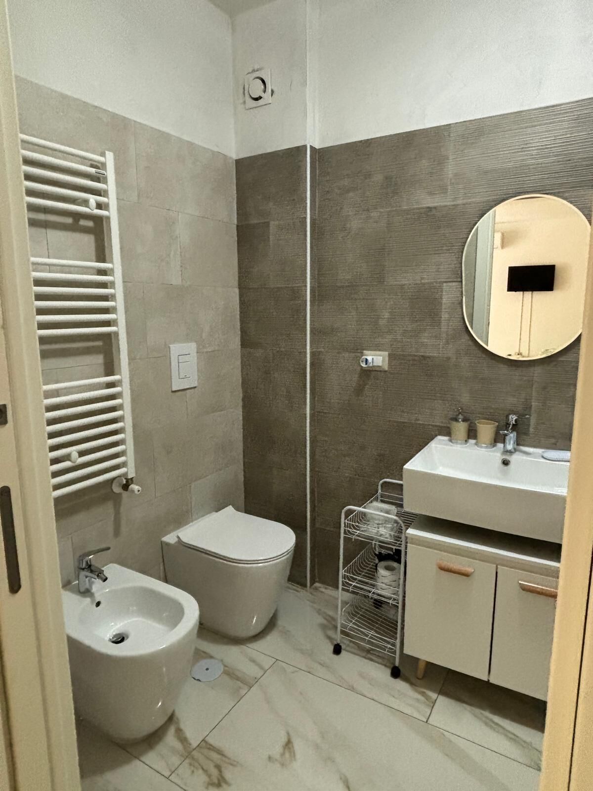 Un baño pequeño con bidé, inodoro, lavamanos y espejo.