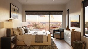 Un dormitorio moderno con una cama grande, una mesita de noche, una silla, un aparador y vistas a un paisaje desértico.
