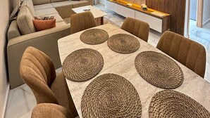 Un salon moderne avec un canapé, un téléviseur et un coin repas.