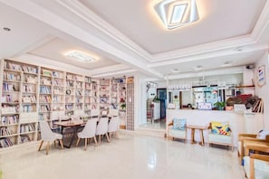 A library with bookshelves, a reading area, and a counter.