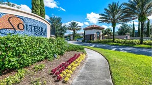A resort entrance with a sign, well-maintained landscaping, and a clear sky. - Villa Du Soleil (Davenport)