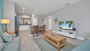 A modern living room with a TV, sofa, and coffee table. - 5419 Oakgrain (Davenport)