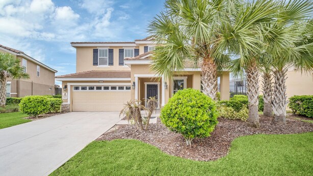 A two-story residential building with a garage, palm trees, and well-maintained lawns. - 5419 Oakgrain (Davenport)