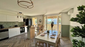 Een moderne keuken met een visgraatvloer, een centraal eiland met zitplaatsen en een uitzicht door een groot raam.