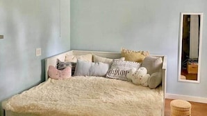 Un dormitorio con cama, vigas de madera, ventilador de techo y espejo.