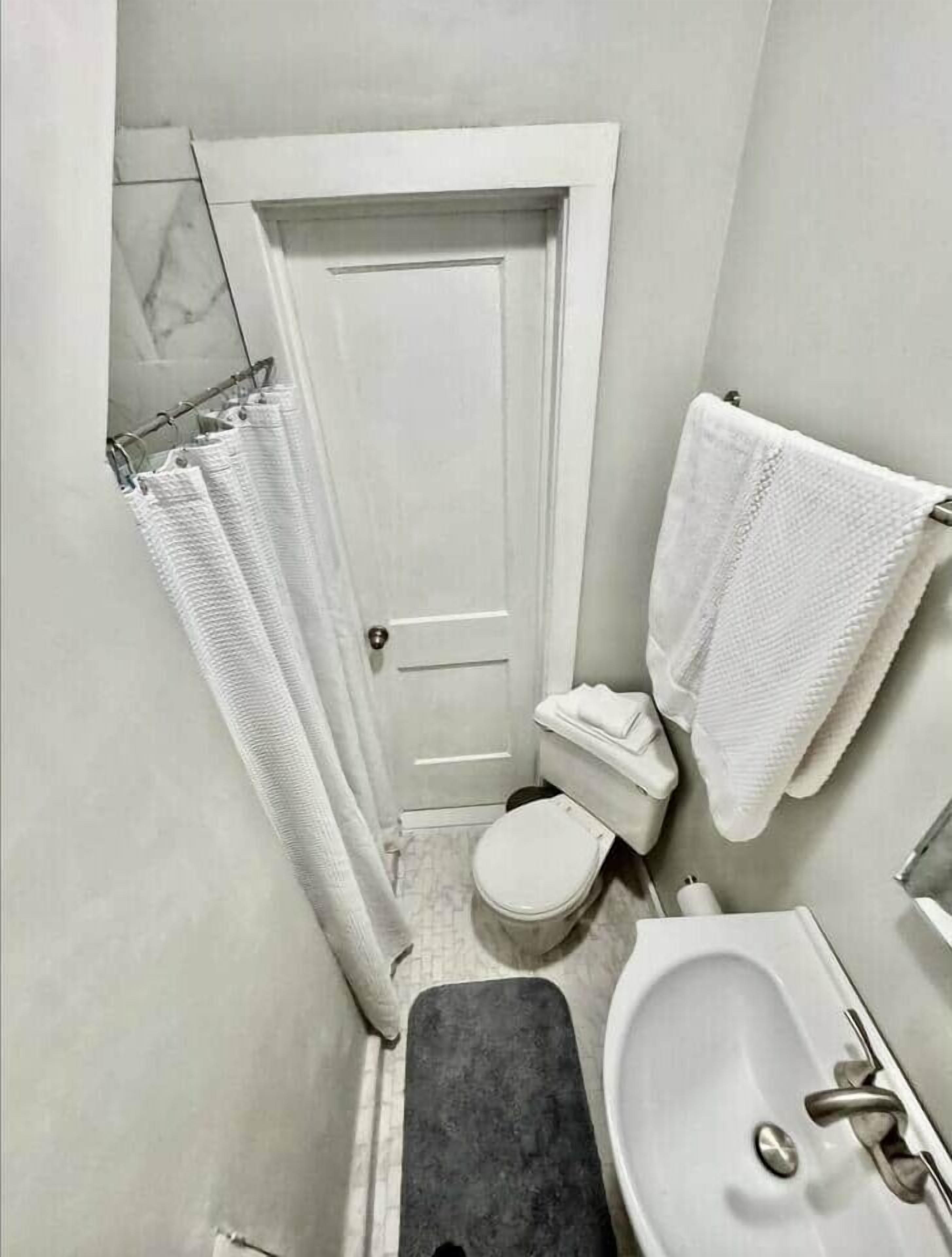Un baño pequeño con inodoro, lavabo y cortina de ducha.
