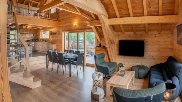 A wooden cabin interior with a dining area, a living room with a sofa and chairs, and a staircase leading to an upper level. - Chalet, 350m from ski slopes, view valley, balcony, tv, ski locker, 205m², Les Orres (Les Orres)