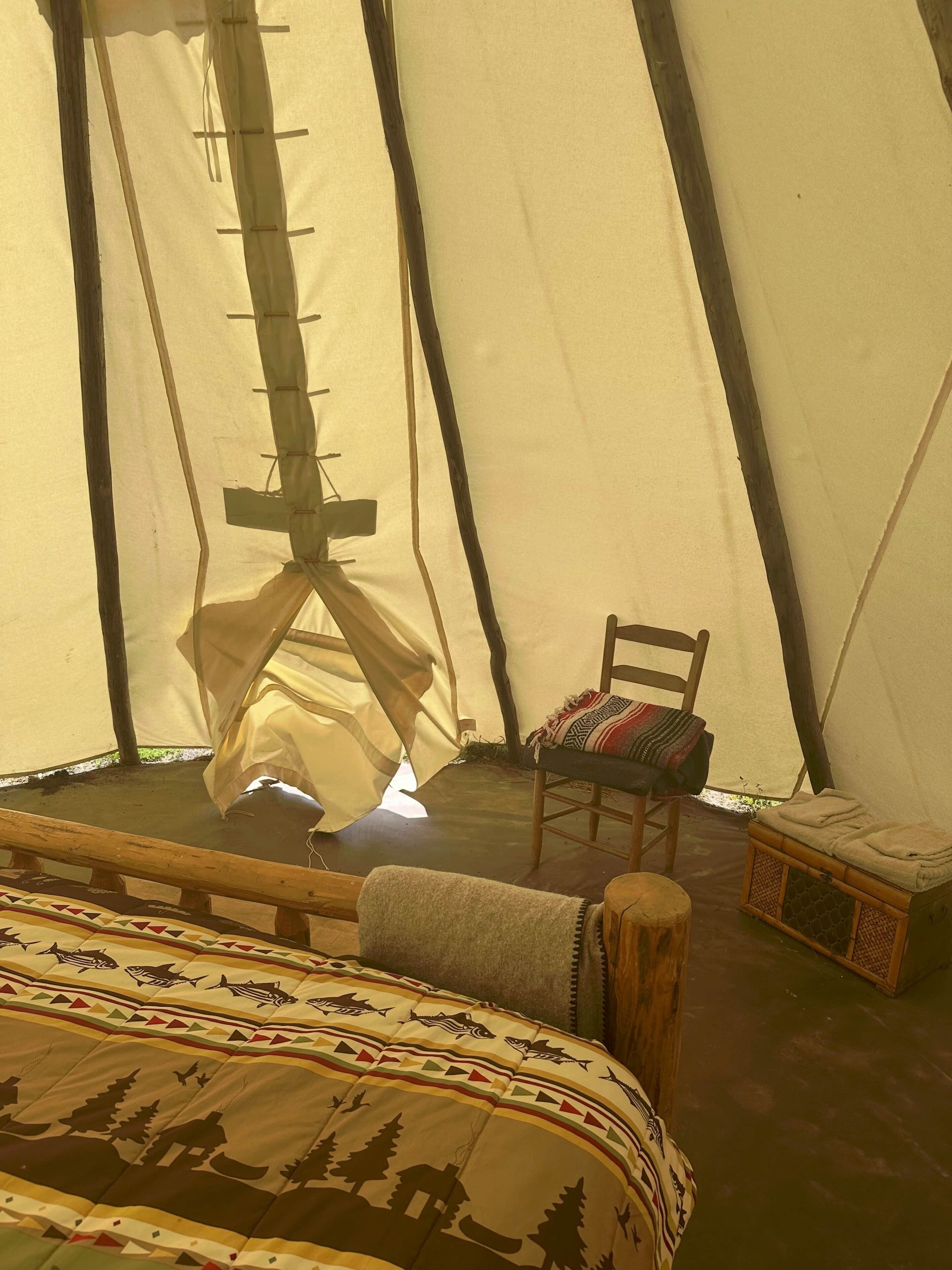 A tent with a bed, a chair, and a small table.