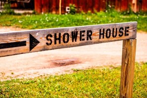 A wooden sign with the words 'SHOWER HOUSE' and an arrow pointing to the right.