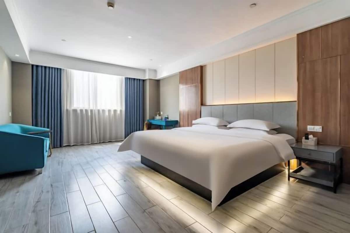 Une chambre d’hôtel moderne avec un grand lit, un bureau et une chaise.