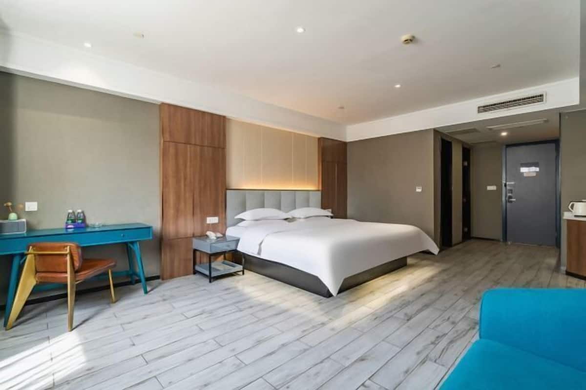Une chambre d’hôtel moderne équipée d’un lit, d’un bureau, d’une chaise et d’une porte.