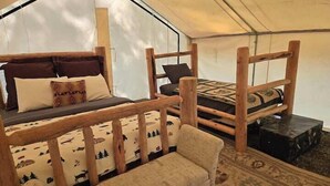 A tent with two wooden beds, each with pillows and blankets. - Homesteader Wall Tent, Homesteader Wall Tent by the Stream (Story)