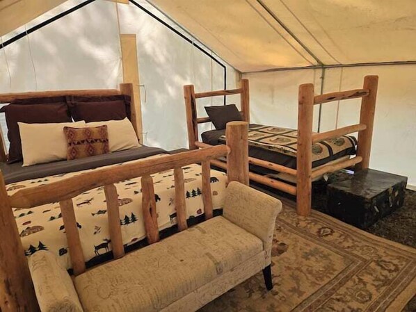 A tent with two wooden beds, each with pillows and blankets. - Homesteader Wall Tent, Homesteader Wall Tent by the Stream (Story)
