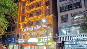 A hotel with multiple floors, illuminated signage, and a variety of shops on the ground floor. - Shankee Chain Hotel (Xinyi Zhongxing Avenue) (Xinyi)