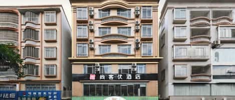 A multi-story building with balconies, a storefront with signage, and a visible awning.