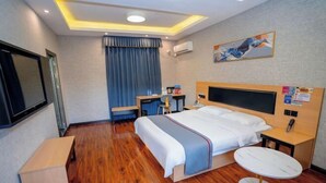 A hotel room with a bed, bedside table, round table, and a TV. - Shankee Chain Hotel (Xinyi Zhongxing Avenue) (Xinyi)
