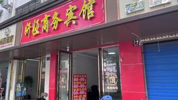 A storefront with a red sign and a blue shutter door.