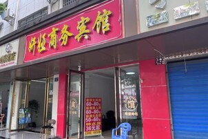 Une devanture de magasin avec une enseigne rouge et une porte à volets bleus.