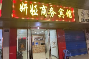 Ein Hotel Eingang mit Neonreklame, Glastüren, einer Rezeption und einer blauen Rolltür.