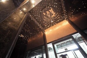 A modern interior with a decorative ceiling light fixture and large windows. - YouJia Apartment (Foshan)