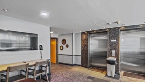 A conference room with a wooden table, chairs, a telephone, and a wall-mounted clock. - Very Cute Studio Next To Ski Slope WiFi Village (Snowshoe)