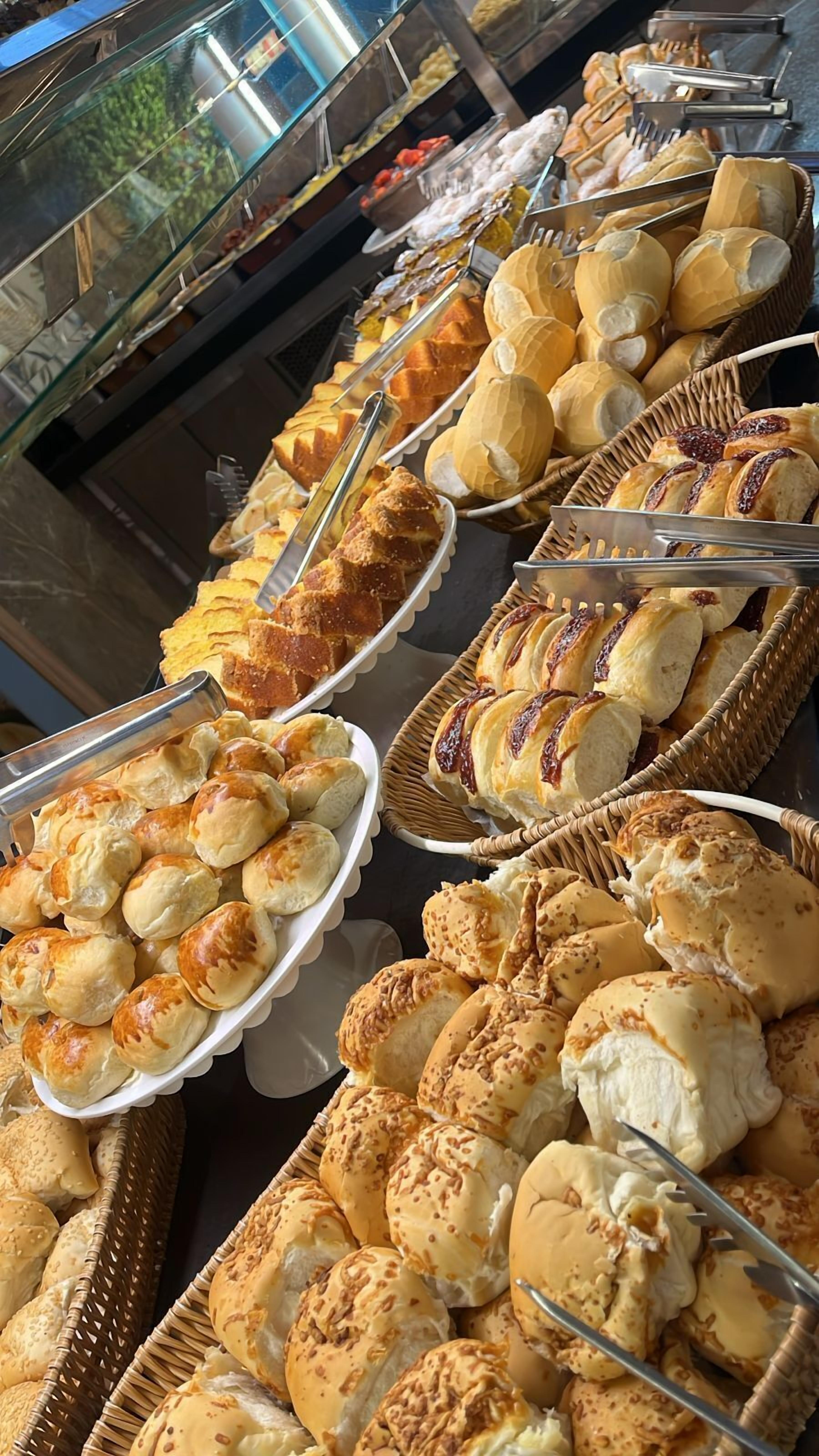 Un bufé con diversas opciones de panadería, incluyendo panes, pasteles y bollos.