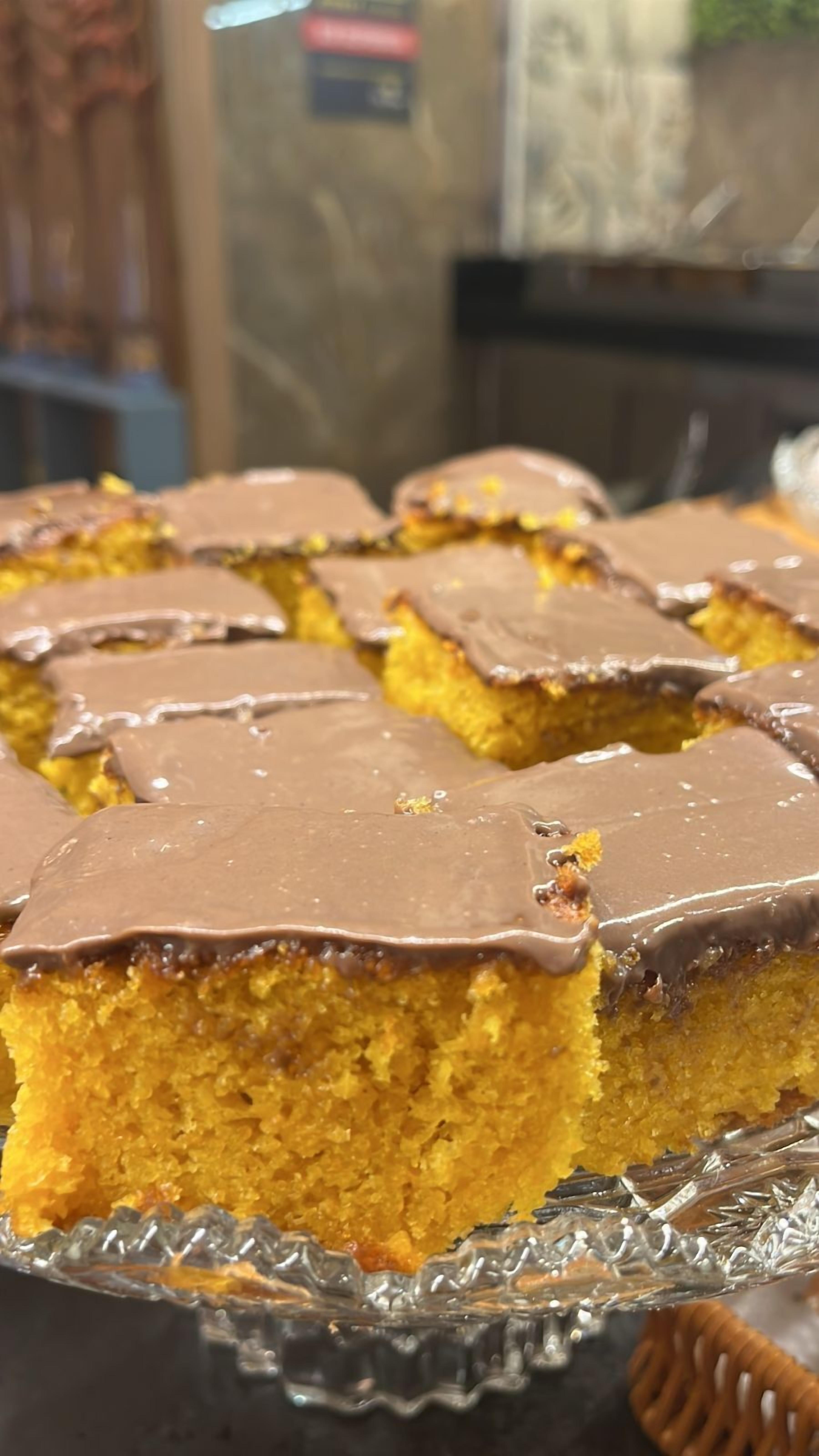 A tray of square-shaped cakes with a golden-brown crust, placed on a glass serving dish.