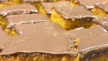 A tray of square-shaped cakes with a golden-brown crust, placed on a glass serving dish.