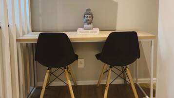 A desk with a bust sculpture labeled "Concrete Jungle" and two black chairs.