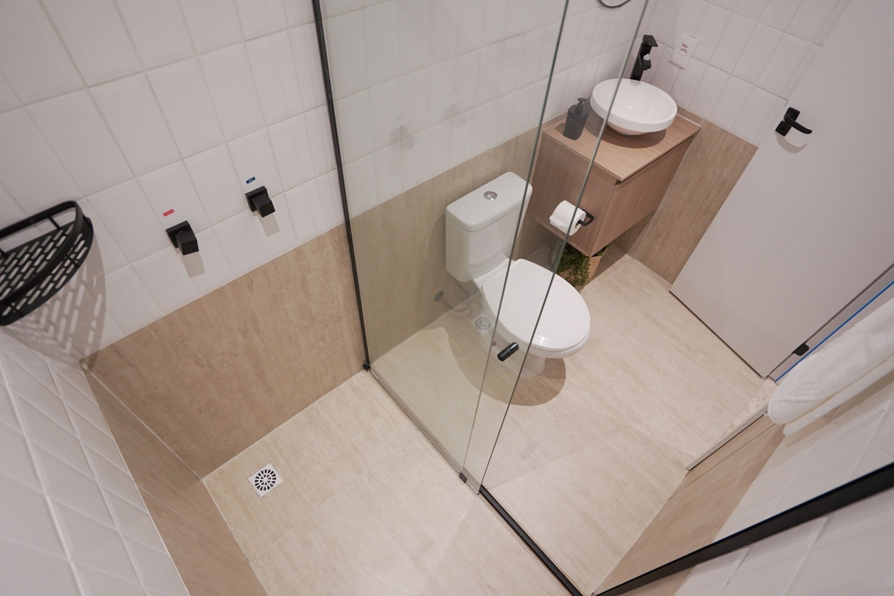 Moderni kylpyhuone, jossa on lasinen suihkuseinä, wc ja pesuallas.
