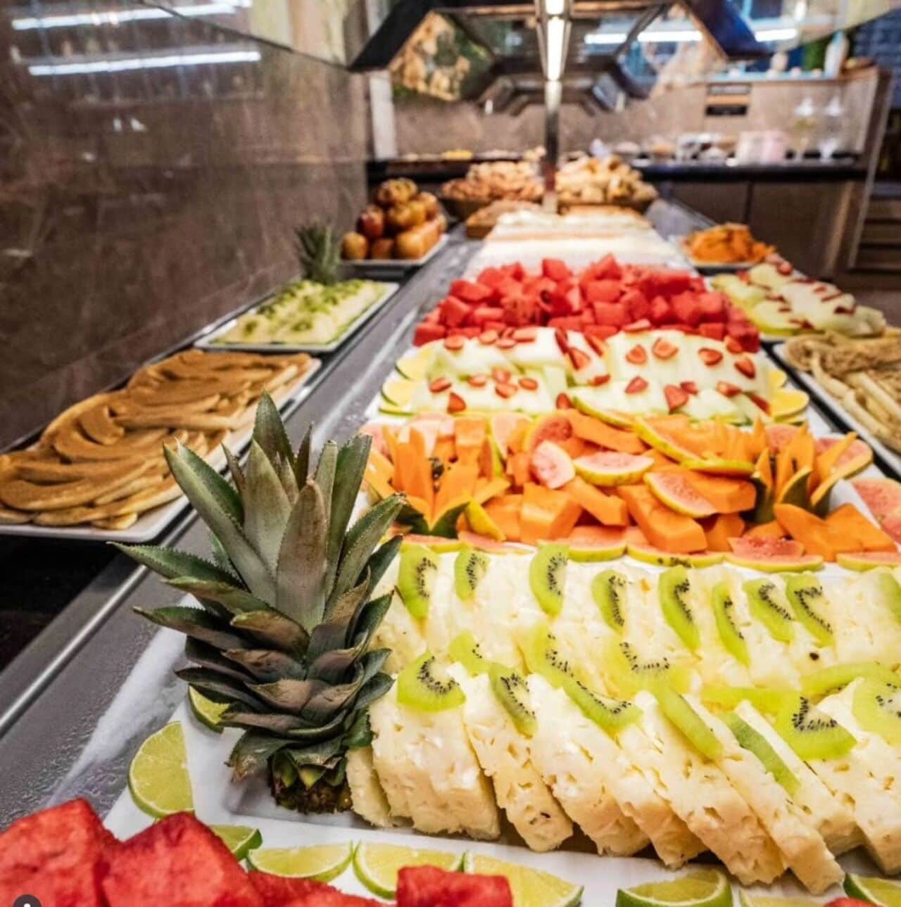 A buffet with various fruits and pastries.