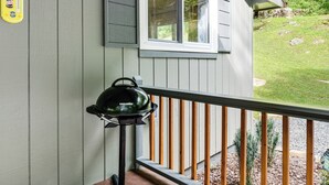 A balcony with a grill, a window with white shutters, and a Pepsi Cola poster on the wall. - 6 Mi to Waterrock Knob: 'Serenity Cottage' (Maggie Valley)