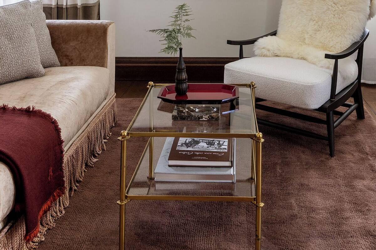 A living room with a sofa, a chair, a coffee table, and framed pictures on the wall.