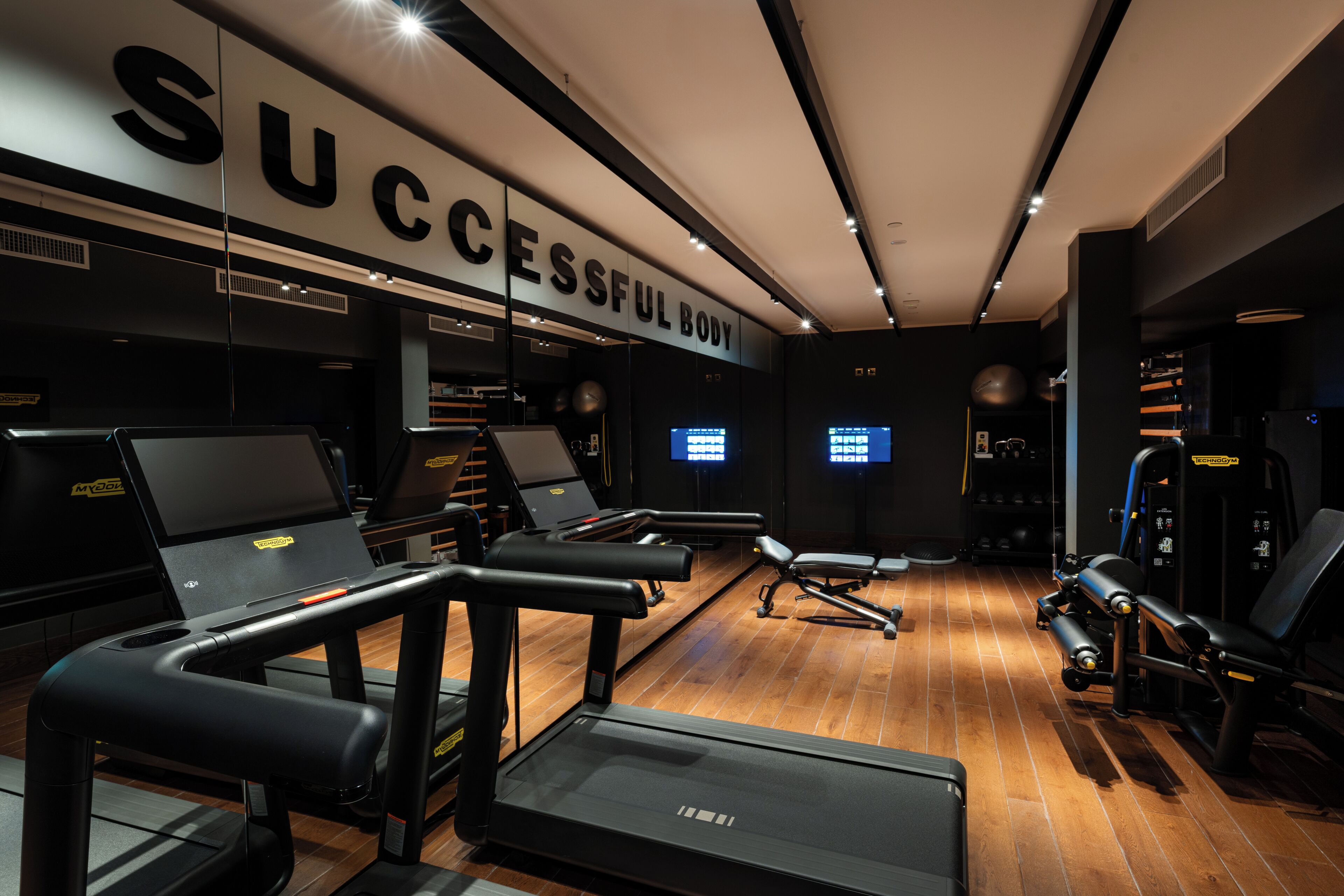 Una palestra con tapis roulant, cyclette e macchinari per pesi.