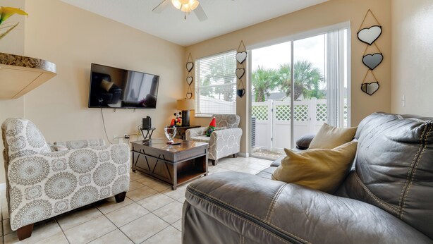 A living room with a sofa, armchairs, a coffee table, and a TV. - 4 Mi to Disney! Family Townhome w/ Pool Access (Kissimmee)