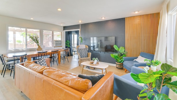 A modern living room with a leather sofa, a blue armchair, and a dining area with a table and chairs. - Water Views & Close to Beach: Home in Lake Havasu (Lake Havasu City)