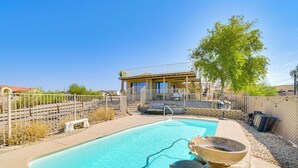 A swimming pool with a stone fountain, a covered seating area, and a fenced patio. - Water Views & Close to Beach: Home in Lake Havasu (Lake Havasu City)