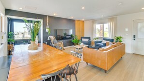 A spacious living area with a wooden dining table, comfortable seating, a flat-screen TV, and large windows offering natural light. - Water Views & Close to Beach: Home in Lake Havasu (Lake Havasu City)