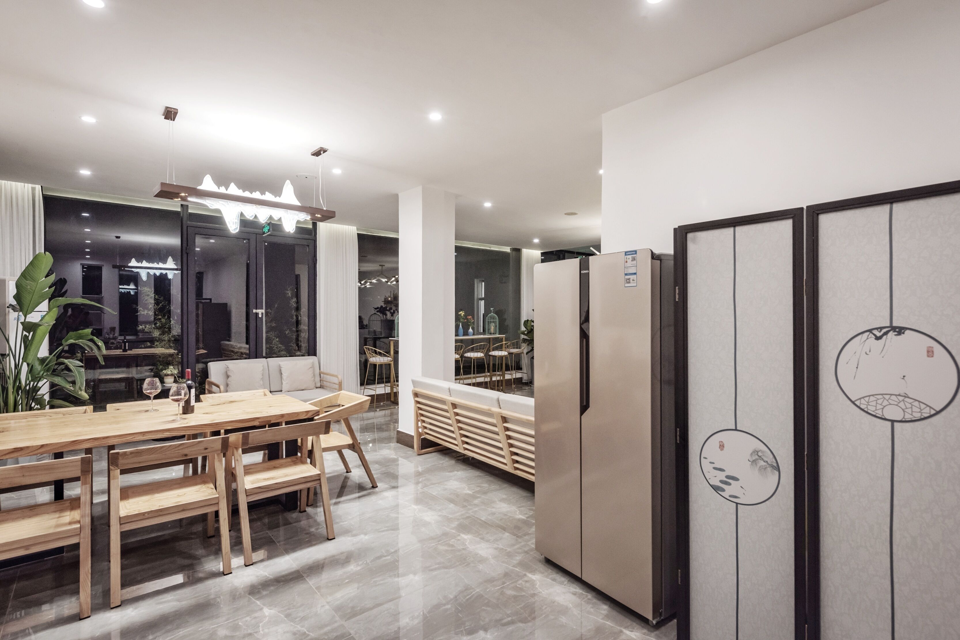 Une cuisine moderne avec une table à manger en bois, des bancs et un réfrigérateur.
