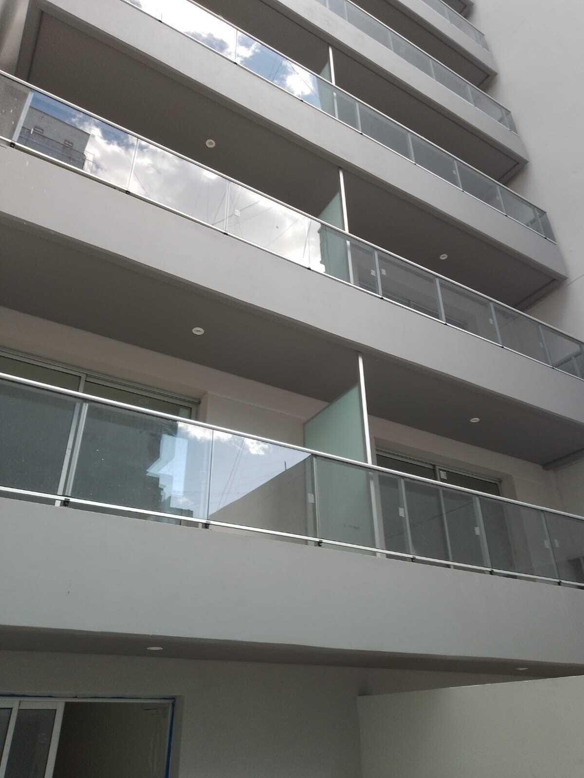A multi-story building with balconies and large windows.