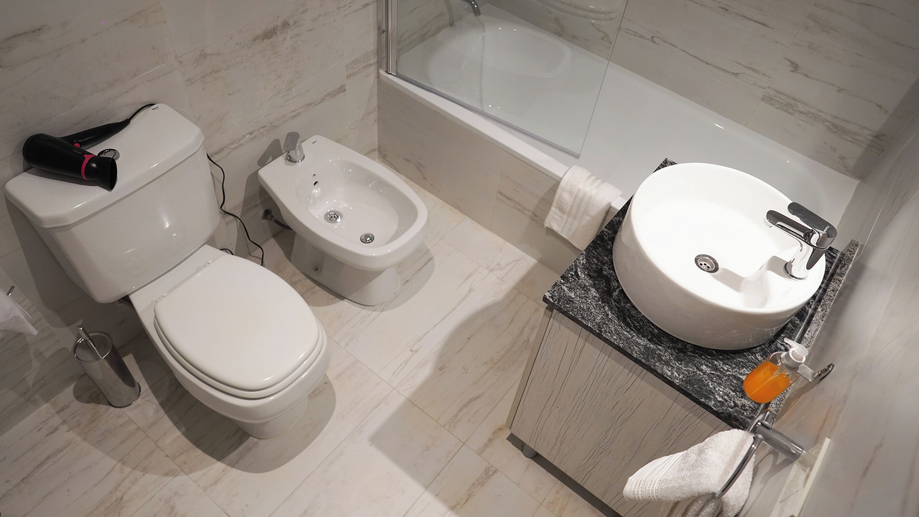 A bathroom with a toilet, bidet, and bathtub.