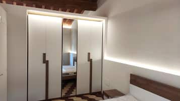 Una camera da letto con un letto, un armadio e uno specchio.