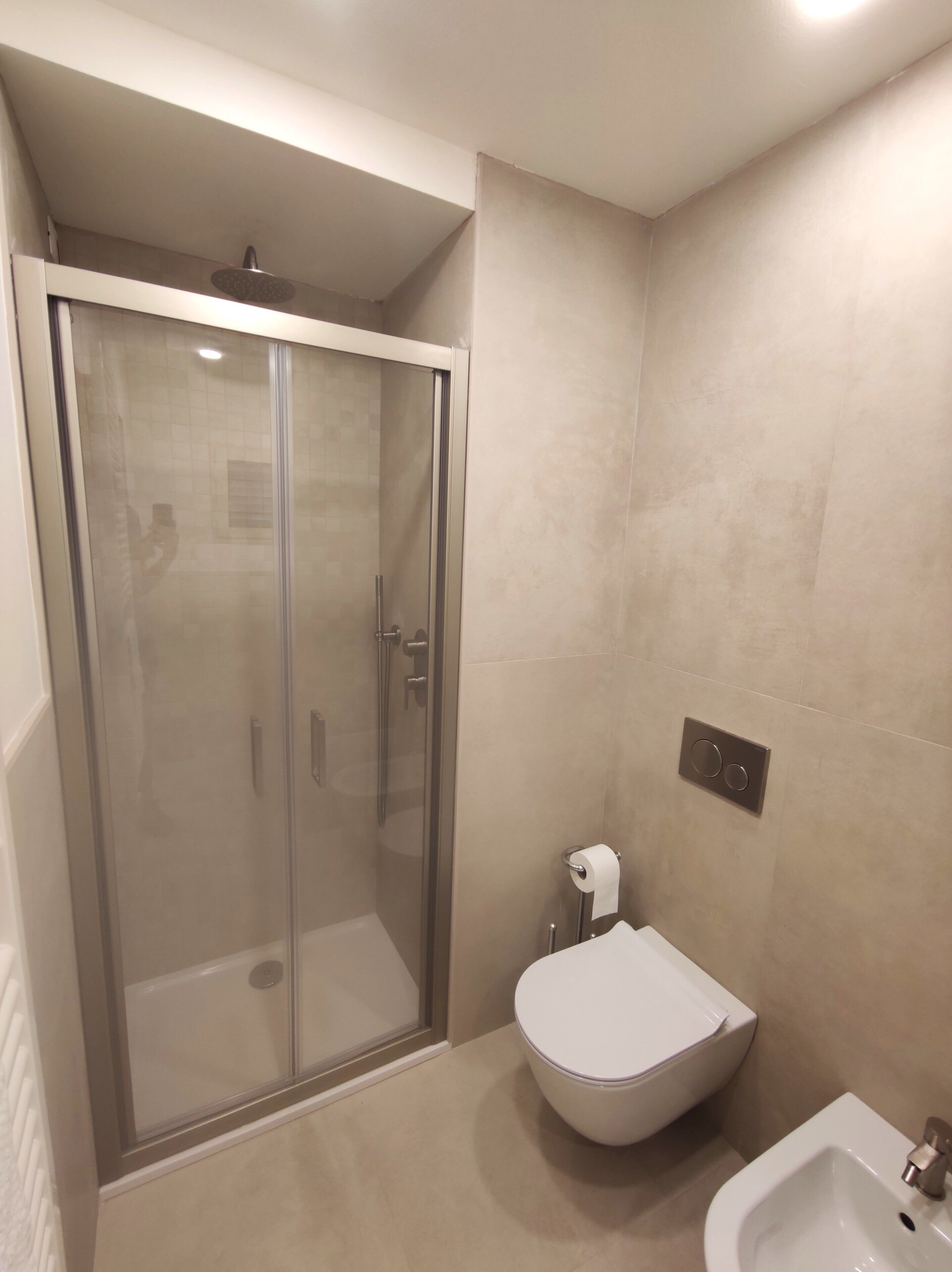 Ein modernes Badezimmer mit einer Duschkabine, einer Toilette und einem Bidet.