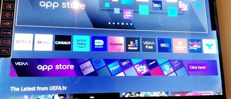 Una pantalla de televisión mostrando una interfaz de tienda de aplicaciones con varios iconos de servicios de transmisión.