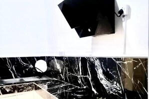 A bathroom with a white wall and a black countertop. - 1 Bed House Private Compound With Off Road Parking (Accra)
