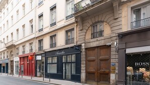 A street view with a row of buildings, including a store with a black awning and a sign that reads "Acanthes." - Fenêtre sur cour - Studio pour 2 (Lyon)