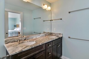 Une salle de bain avec deux lavabos, des meubles sombres et un grand miroir.